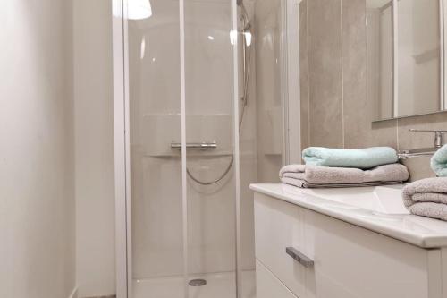 格朗维尔Le Corsaire appartement centre ville 500 mètres des plages的带淋浴的浴室和台面毛巾