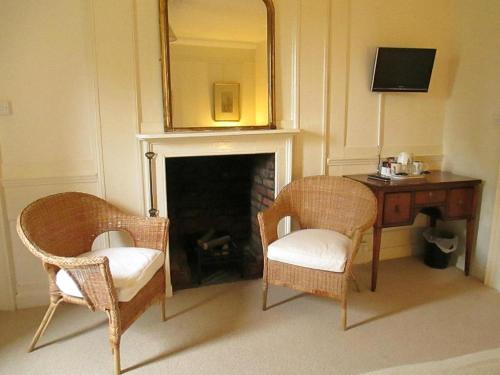 谢珀顿Old Manor House的一间设有两把椅子、一张桌子和一面镜子的房间
