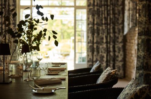 皮利尼蒙特拉谢COMO Le Montrachet的一间带桌椅和窗户的用餐室