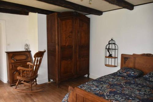 Marcillac-la-CroisilleLe hameau de Donnedevie的一间卧室配有一张床、一个木制橱柜和一把椅子