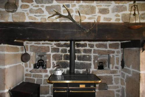 Marcillac-la-CroisilleLe hameau de Donnedevie的石制厨房设有水槽和石制壁炉
