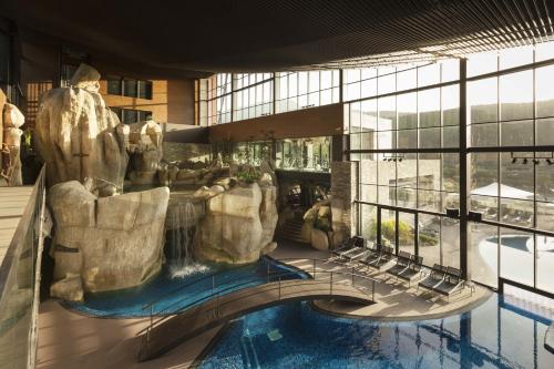 安旱斯达塞拉H2hte议会理疗SPA酒店的享有带游泳池和瀑布的度假村景色