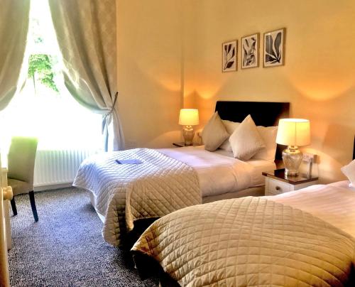 都柏林墨翰普顿联排别墅酒店的酒店客房设有两张床和窗户。