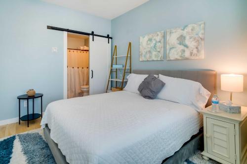 大洋城Modern Ocean City Getaway Walk to Boardwalk!的卧室配有白色的床和带台灯的桌子
