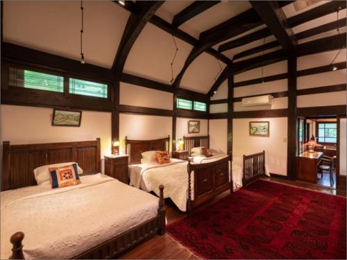 由布市Nihon-no-Ashitaba的一间大卧室,配有两张床和红色地毯
