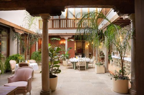 格拉纳达La Corrala del Realejo的一间设有桌椅和盆栽的餐厅