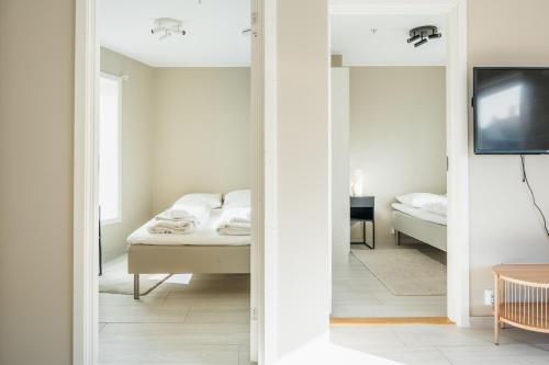 卑尔根Stay Urban - Perfect location的一间卧室配有一张床、一台电视和一面镜子