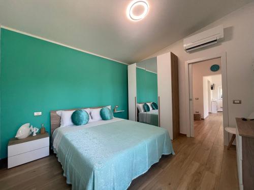 阿祖罗港Villetta Palmina的一间卧室设有一张蓝色墙壁的大床