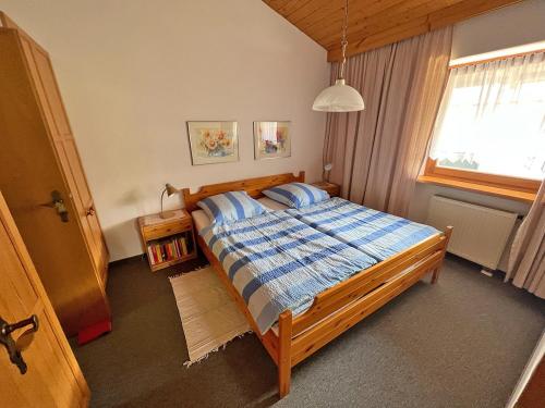 卑尔根Ferienwohnung Wagner的一间卧室配有一张带蓝色棉被的床和窗户。