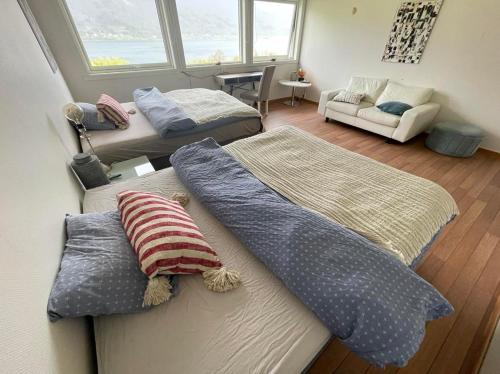 HovTjeldøya Slott的客房设有两张床和一张带枕头的沙发。