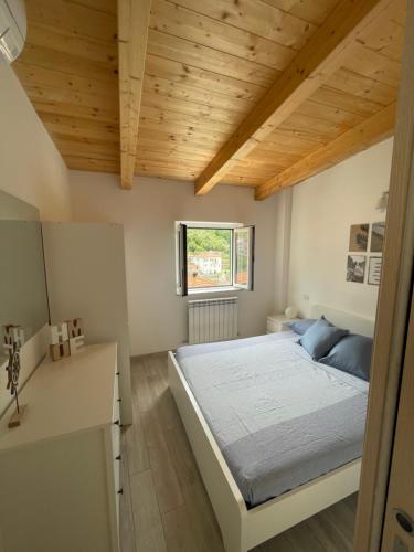 莫内利亚Da Pippo的一间卧室设有一张床和木制天花板