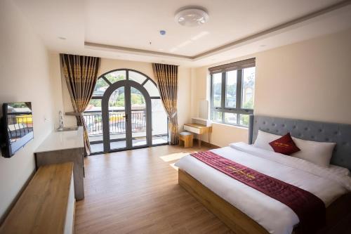 大叻Thung Lũng Xanh TQK Hotel的一间卧室设有一张床和一个大窗户