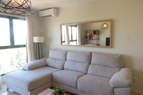 卡耐特蒂贝兰格Precioso apartamento en Canet Playa by Hometels的客厅配有一张白色沙发,配有镜子