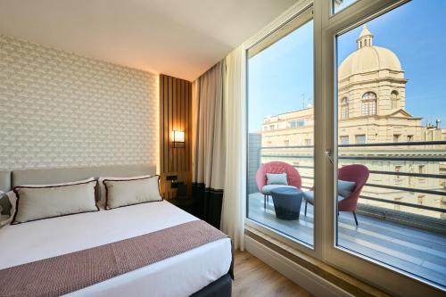 巴塞罗那加泰罗尼亚兰布拉大道酒店的酒店客房设有一张床和一个大窗户