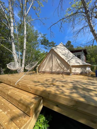 玛丽港Glamping Tent Mariehamn的木制甲板上的圆顶帐篷,配有两把椅子