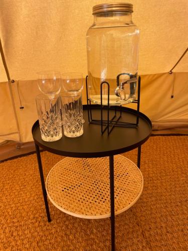 玛丽港Glamping Tent Mariehamn的一张带眼镜和罐子的黑桌