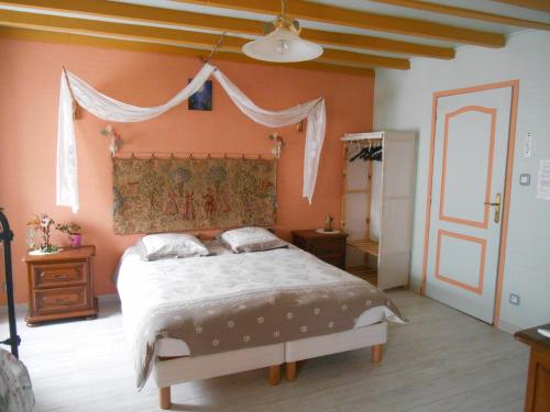 TaintruxAu val des meuris的一间卧室配有一张带橙色墙壁的大床