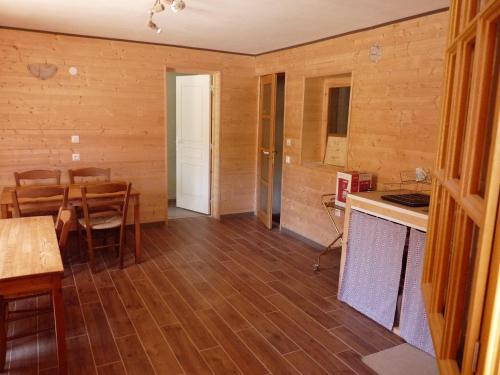 TaintruxAu val des meuris的一间厨房、一间铺有木地板的用餐室和一张桌子