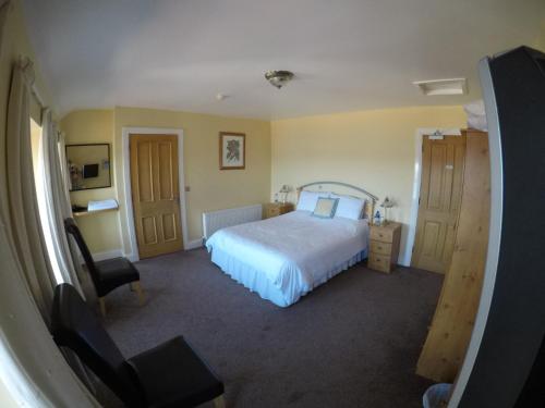 巴里格曼海景小酒馆酒店的一间卧室配有一张床、一张桌子和一把椅子