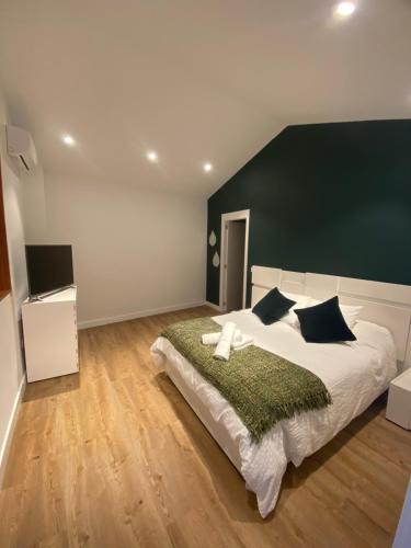 克鲁兹·德·特赫达Casa El Mirador del Almendro的一间卧室配有一张白色大床和绿色床头板