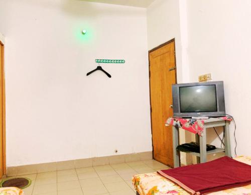 达卡Mohammadia Restaurant & Guest House Near United Hospital的一间白色墙壁上配有电视的房间