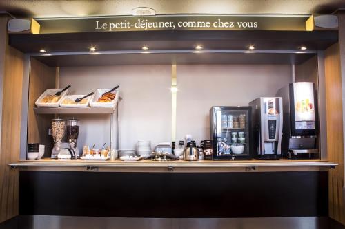 蒙吕松Hotel Inn Design Montluçon的咖啡店,带咖啡机的架子