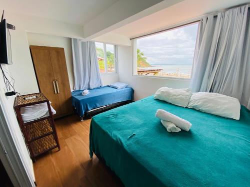 莫罗圣保罗Casa de Praia的一间卧室设有蓝色的床和大窗户