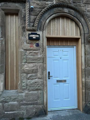 Laurieston Inn的石头建筑的蓝色门,有门