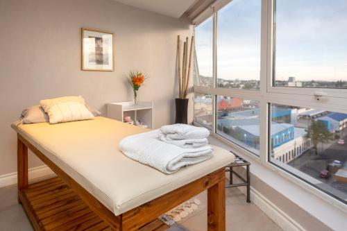 圣路易斯Visit Hotel & Apart的一张位于带大窗户的房间内的床铺
