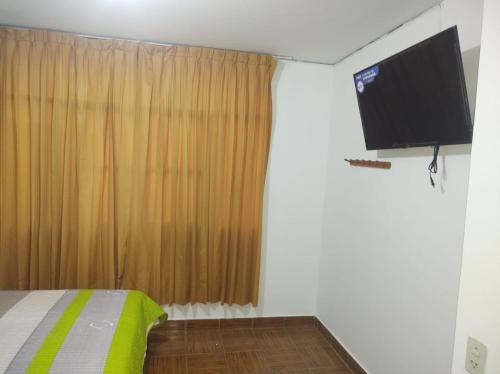 纳斯卡CasaBlanca的一间卧室配有一张床和一台平面电视