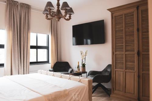博尔赫隆La Forteresse的一间卧室配有一张床、两把椅子和一台电视