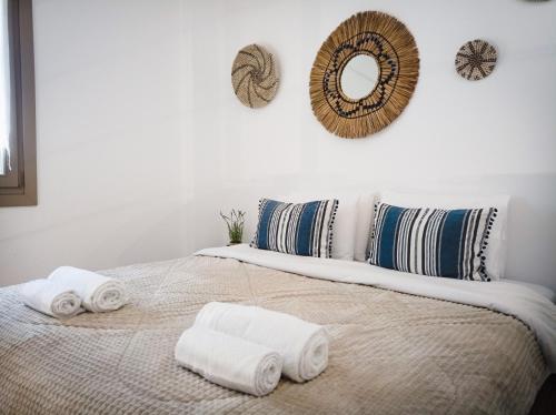 MakrirrákhiSerenity Living Pelion的一间卧室,在床上配有毛巾和镜子
