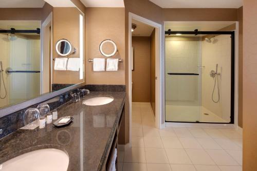 普兰塔寻Sheraton Suites Fort Lauderdale Plantation的一间带两个盥洗盆和淋浴的浴室