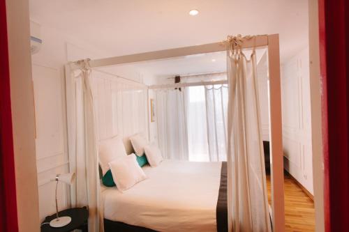 塔那那利佛Le Cocooning 974 Hôtel Restaurant Réunion的一间卧室配有一张天蓬床和窗户