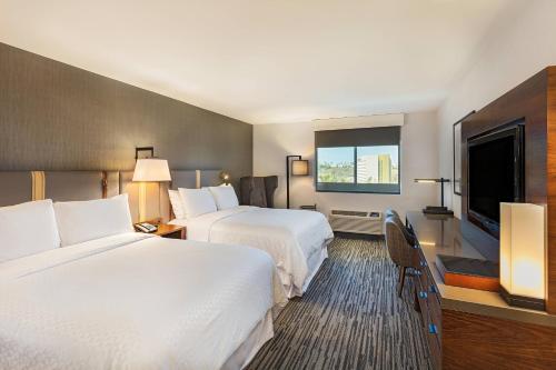 洛杉矶登洛杉矶西部福朋喜来登酒店的酒店客房设有两张床和一台平面电视。
