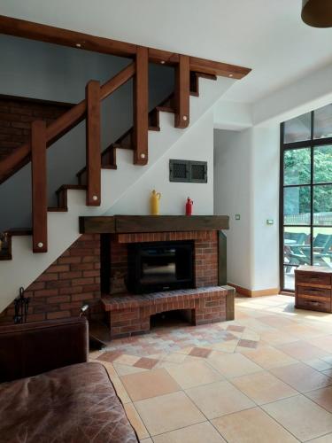 BradCASA DIN PADURE的一间带砖砌壁炉和楼梯的客厅
