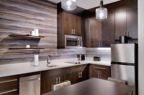 布伦瑞克Residence Inn by Marriott Brunswick的厨房配有木制橱柜和不锈钢冰箱。