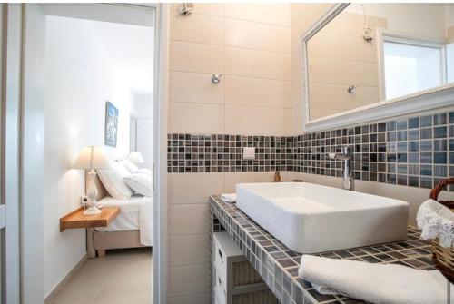 斯泰里达Villa Sofia的一间带大型白色水槽的浴室和一间卧室