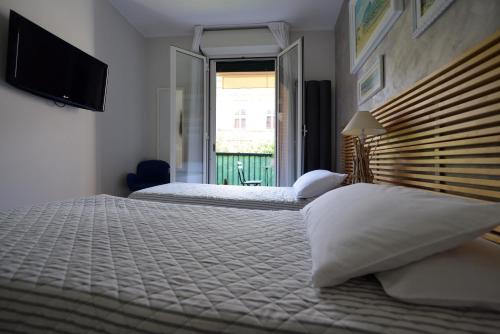 雷卡纳蒂港mentamarina的一间卧室设有两张床、一台电视和一扇窗户。