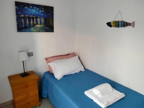 阿尔卡拉Alcalá Center Playa的一间卧室配有蓝色的床和床头柜