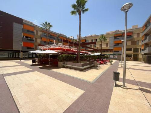 阿尔卡拉Alcalá Center Playa的一座带桌子和遮阳伞的庭院