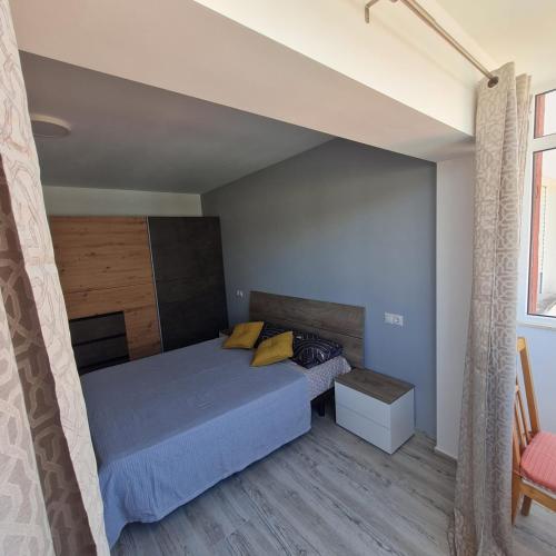 比纳罗斯Apartament Lux的一间卧室配有一张带蓝色床单和黄色枕头的床。