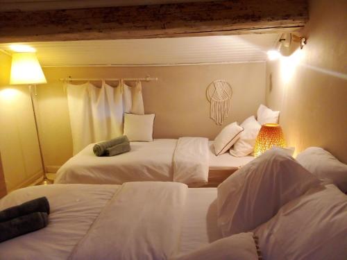 艾格-莫尔特La maison perchee的酒店客房,配有两张带白色床单的床