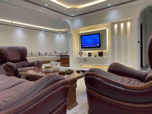 非斯Luxury apartment的客厅配有皮革家具和平面电视