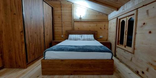 巴统Wooden House Garetke的小木屋内一间卧室,配有一张床