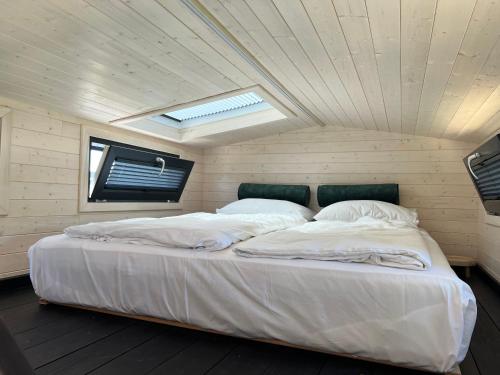 羊角村Tiny House Lovely Sunshine的天花板客房内的一张大白色床
