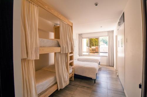 门多萨Fuxia Jungle Hostel的客房设有两张双层床和一扇窗户。