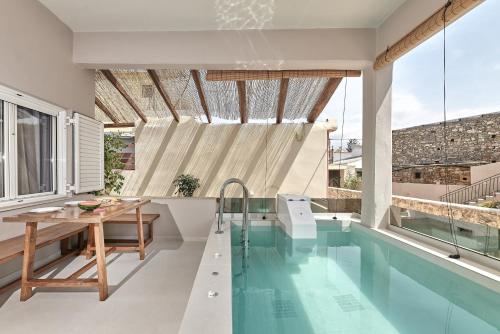 Melidhónion2 bedroom Villa with heated swimming pool-Spa whirlpool-BBQ!的一个带游泳池和桌子的房子