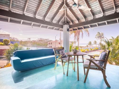 下维加Ocean Front Villa, 2 Private Pools, BBQ, Tennis court and more!的客厅配有蓝色的沙发和桌子