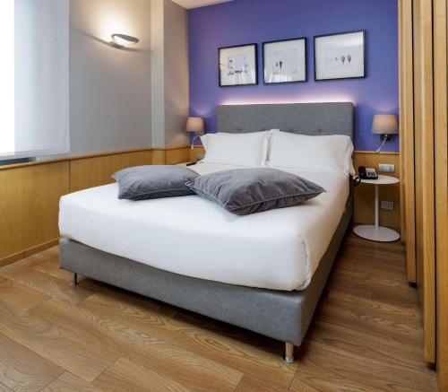都灵贝斯特韦斯特行政套房酒店的卧室配有一张白色大床和紫色墙壁